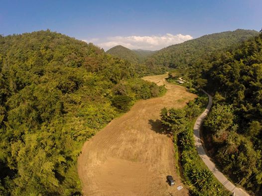 Cleared land surrounded by forested hills in Chiang Mai, Thailand
